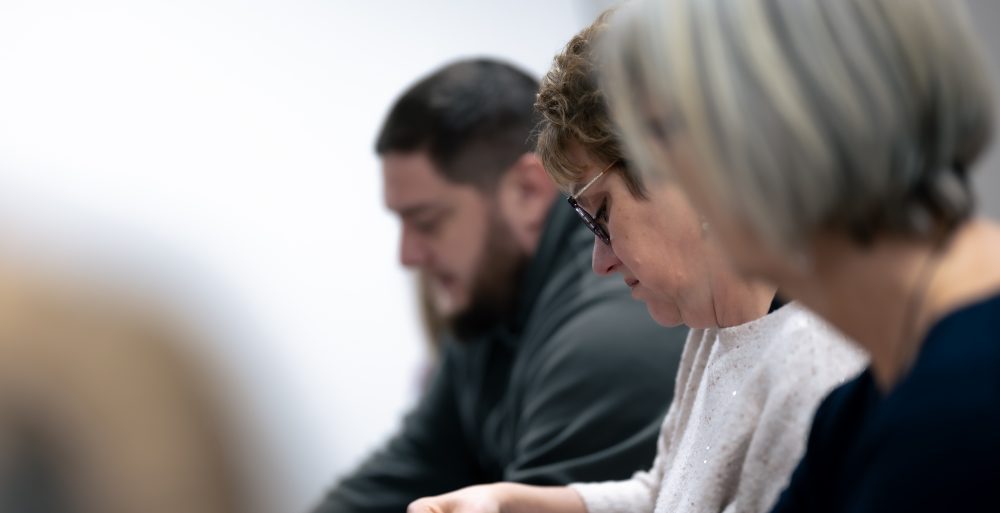 Patients concentrés lors d’un atelier collectif au Centre Phenix Grenoble, travaillant sur des supports pédagogiques dans le cadre du parcours contre l’obésité.