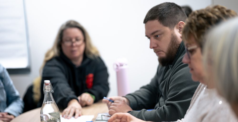 Patients concentrés lors d’un atelier collectif au Centre Phenix Grenoble, travaillant sur des supports papier dans le cadre du parcours contre l’obésité.